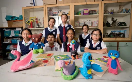 a group of children sitting at a table with toys