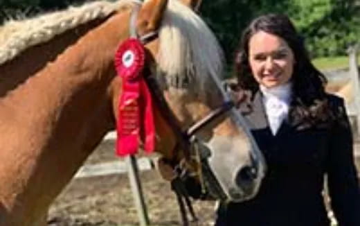 a person standing next to a horse