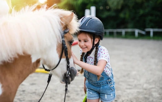 a girl with a helmet and a horse