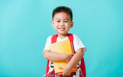 a boy holding a yellow book