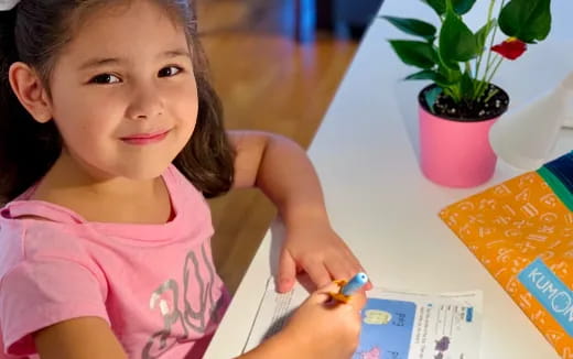 a girl holding a pencil