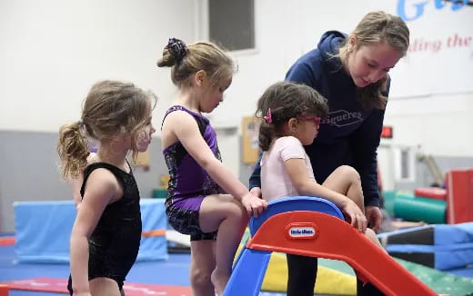 a group of girls playing on a gym mat