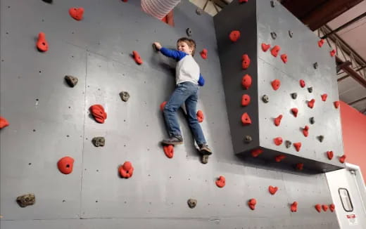 a boy climbing a rock wall
