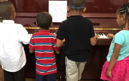 a group of people playing piano