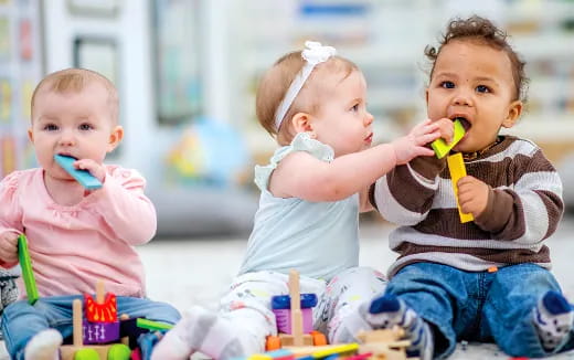 a group of kids sit on the floor with tooth brushes