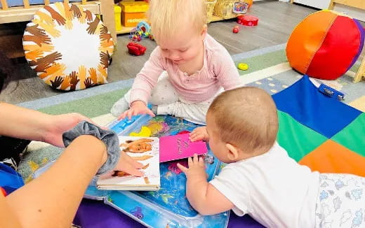 a person and a baby sitting on the floor
