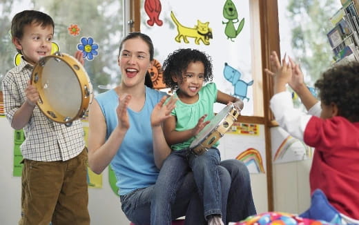 a group of kids holding up a large drum