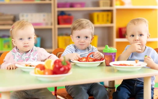 a group of kids eating at a table