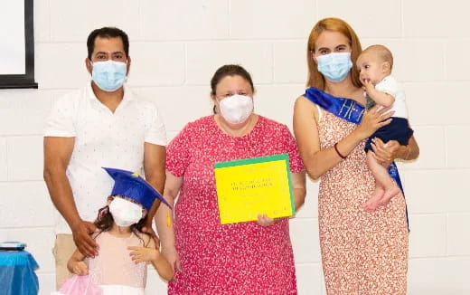 a group of people wearing masks and holding a baby