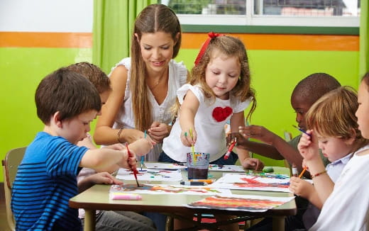 a group of children sitting around a table