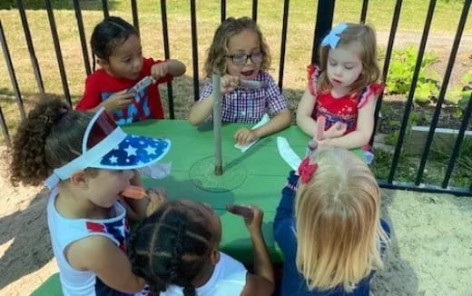a group of children sitting around a table
