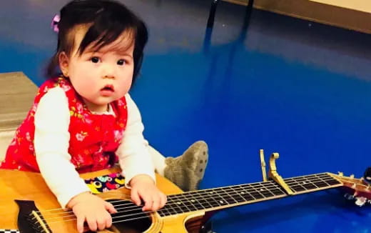 a baby playing a guitar
