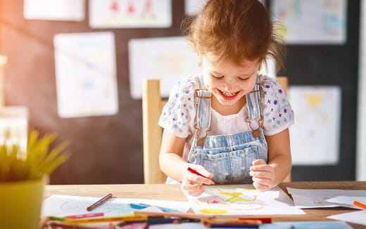 a young girl coloring on a paper