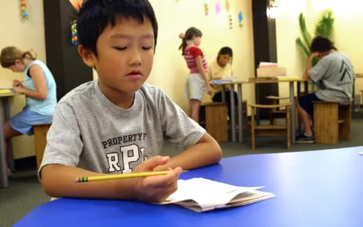 a young boy sitting at a table
