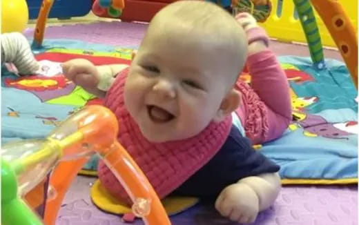 a baby lying on a colorful blanket