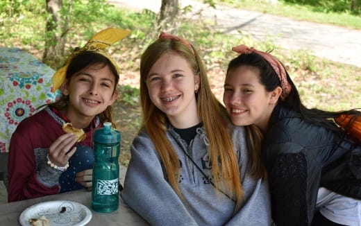 a group of girls sitting at a table outside