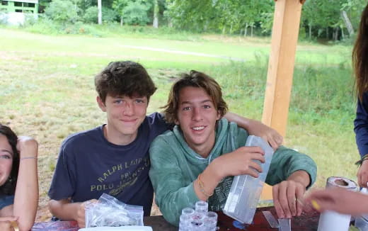a group of people sitting at a table outside