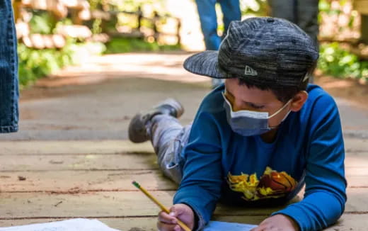 a boy wearing a mask and holding a stick