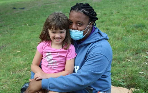 a person and a child sitting on grass