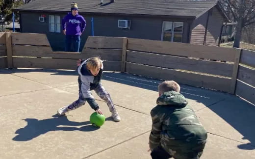 a group of people playing with a ball in a yard