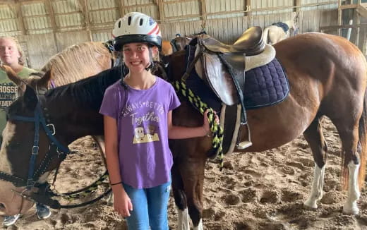 a person standing next to a horse