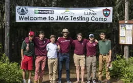 a group of people posing for a photo under a sign