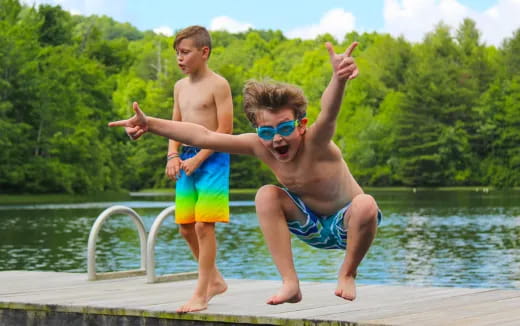 two boys jumping into water