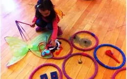 a girl drawing on a wood floor