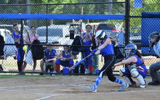 a girl swinging a baseball bat