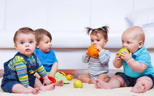 a group of babies sitting on the floor