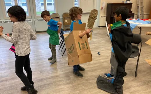 a group of children holding cardboard boxes