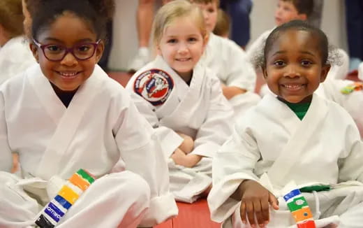 a group of children in white uniforms