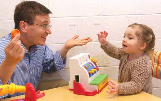 a person and a child playing with toys