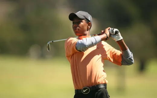 a person swinging a golf club