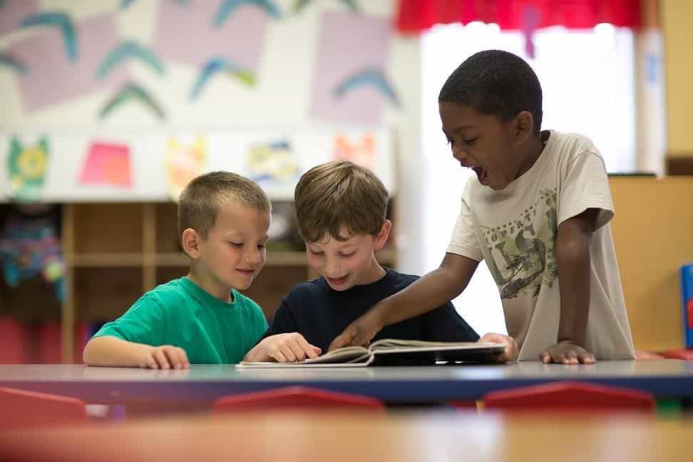 a few boys looking at a book